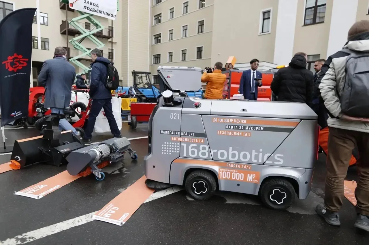 Посетители осматривают экспозицию рядом с фирменным флагом TOSS Service.